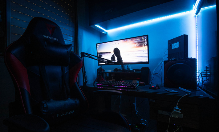 Computer gaming room with blue hue lights illuminating the room. 